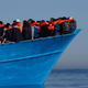 Migrants on a wooden boat await rescue by the Malta-based NGO Migrant Offshore Aid Station (MOAS) in the central Mediterranean